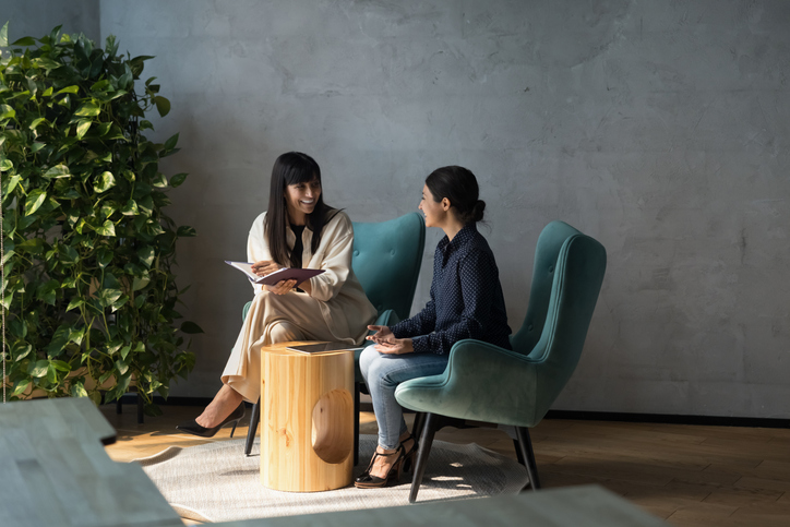 Two women sitting down discussing marketing
